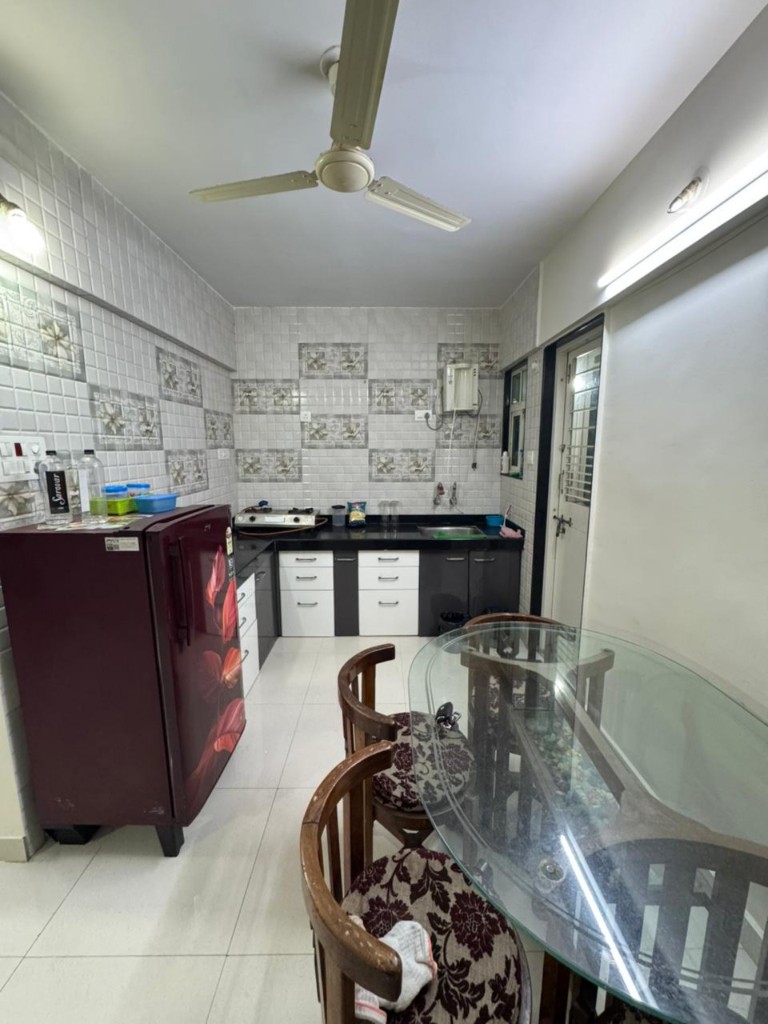 Kitchen with refrigerator, hob and dining table