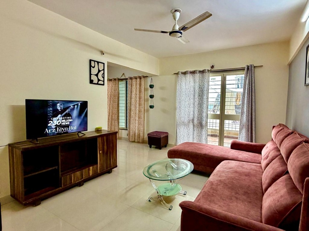 Living room at STAYORA BALEWADI with seating, television and natural light